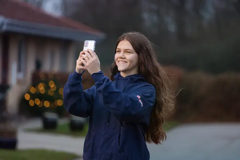 Pige tager billede med telefon